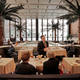 In this July 12, 2016 photo, a waiter speaks with diners in the Pool Room of The Four Seasons, in New York's landmarked Seagram building, which has housed the restaurant for 57 years. Designed by the legendary architect Philip Johnson and the building's architect Ludwig Mies van der Rohe, the restaurant was a favorite of celebrities and business titans ever since it opened in 1959. The epitome of the midcentury style in Midtown Manhattan, The Four Seasons is scheduled to close on Saturday, July 16. (AP Photo/Richard Drew)